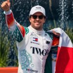 Checo Pérez saluda con la bandera mexicana durante su exhibición en Paseo de la Reforma.