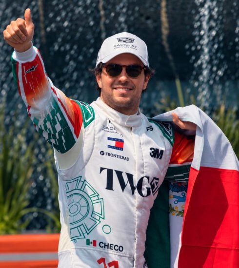 Checo Pérez saluda con la bandera mexicana durante su exhibición en Paseo de la Reforma.
