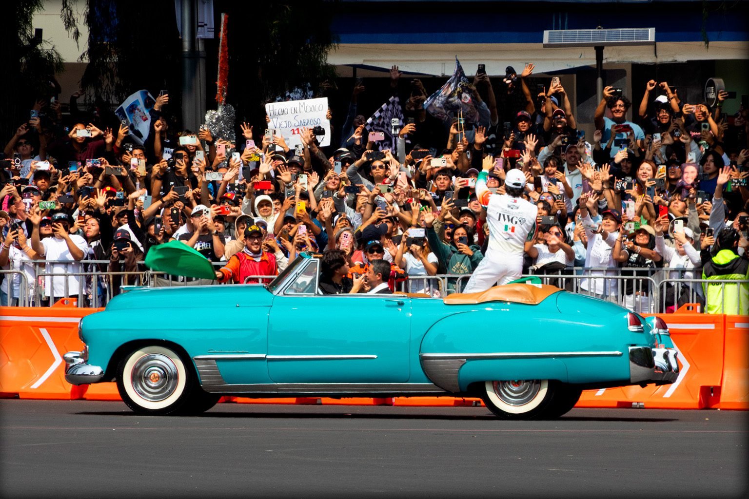 Checo Pérez saluda a sus aficionados desde un Cadillac clásico azul