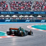 Automóvil de carreras en pista, con tribunas al fondo